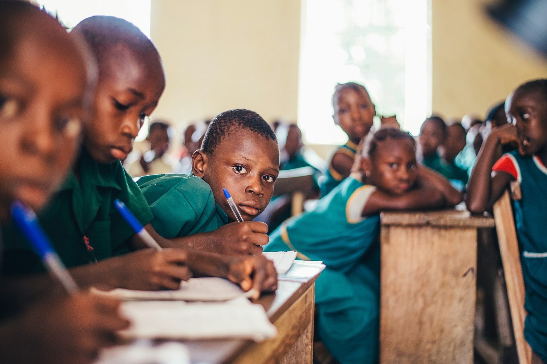 Pupils writing at their desks in a classroom