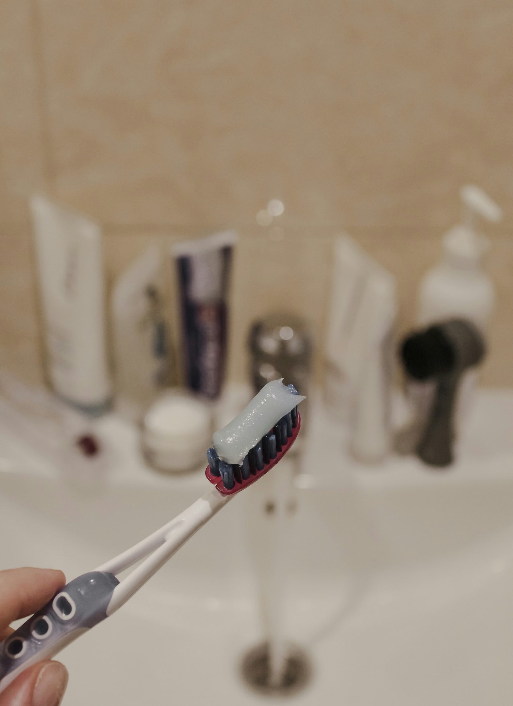 A toothbrush with toothpaste at a sink